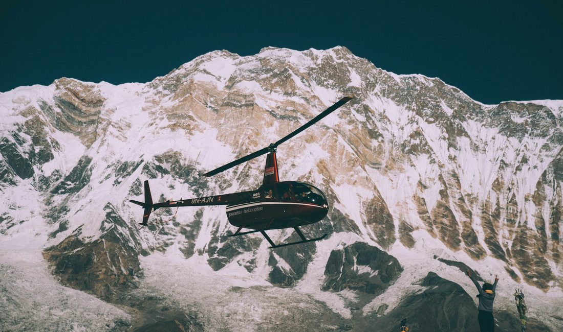 Helicopter flying past a Himalayan ice face